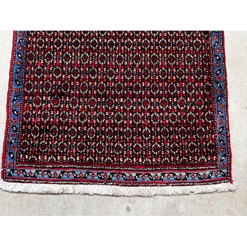 546 - All over floral hand knotted wool carpet with blue border, approx 71cm x 102cm