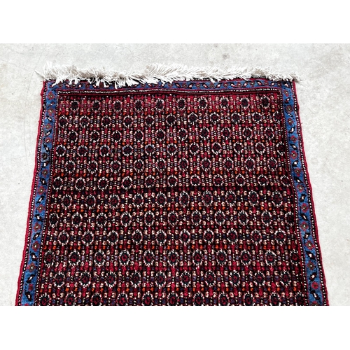 546 - All over floral hand knotted wool carpet with blue border, approx 71cm x 102cm