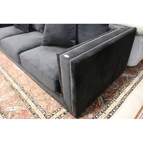 40 - Modern as new, black velour four seater couch, with loose cushions. Double brass studded trim, appro... 