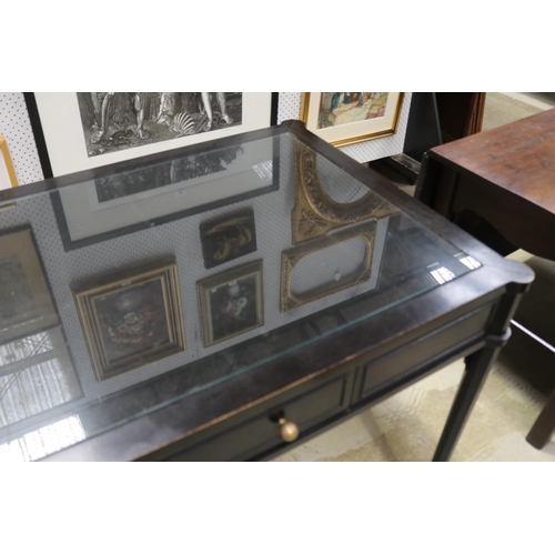 580 - Stylish ebonized single drawer desk, with inset glass top.  tapering legs, brass caps to the tops, a... 