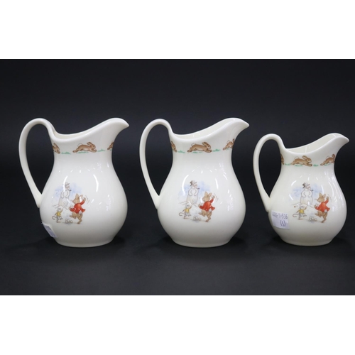 5147 - Royal Doulton, Bunnykins pair of jugs and a smaller example Snow, approx 12.5cm H & smaller (3)