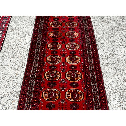 2027 - Hand knotted wool hall runner of red ground, approx 292cm x 75cm