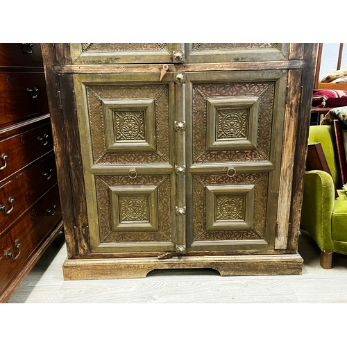 2216 - Large Indian four door cabinet, with applied stepped brass framed panels and applied bosses, approx ... 