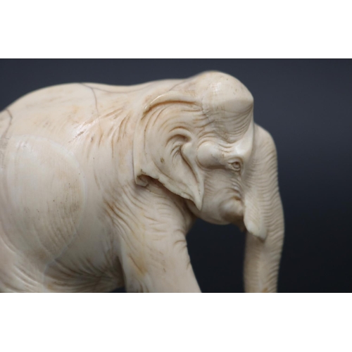 24 - Finely carved ivory figure of an elephant, showing age, approx 7.5cm H x 8cm L