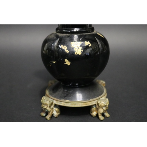 212 - Antique black glass vase with gilt highlight decoration, standing to a dog of fo motif base, approx ... 