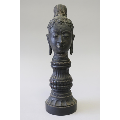 295 - South East Asian bronze Buddha head on carved turned wood stand, approx 32cm H including stand