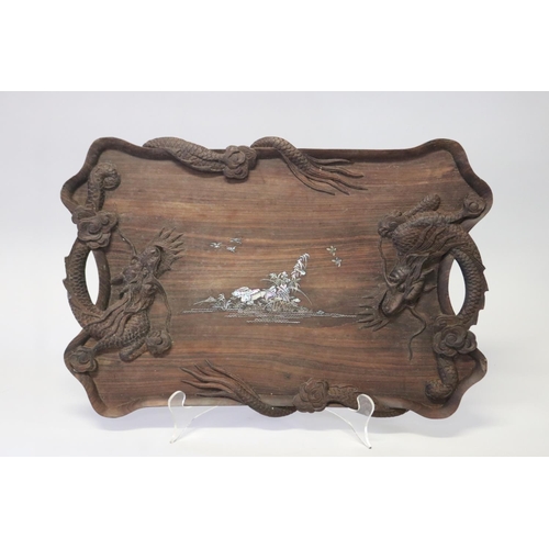 386 - Oriental hardwood twin handled tray decorated with dragon in relief and mother of pearl inlaid cente... 