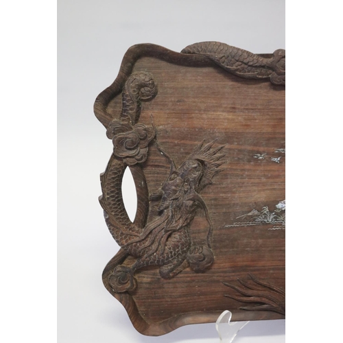 386 - Oriental hardwood twin handled tray decorated with dragon in relief and mother of pearl inlaid cente... 