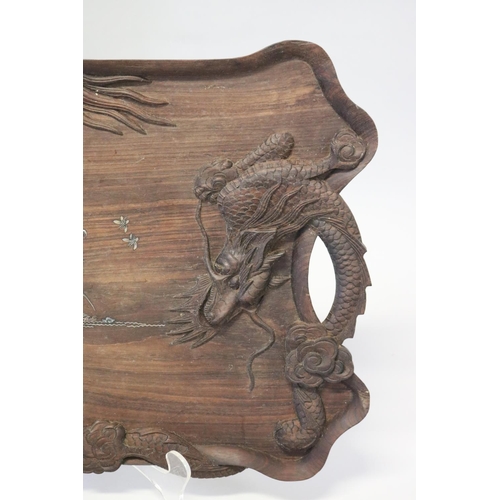 386 - Oriental hardwood twin handled tray decorated with dragon in relief and mother of pearl inlaid cente... 