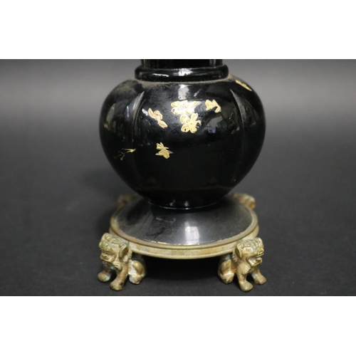 106 - Antique black glass vase with gilt highlight decoration, standing to a dog of fo motif base, approx ... 