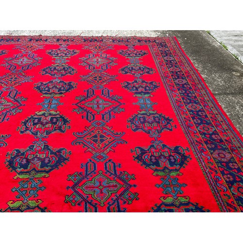 388 - Large Turkoman red ground carpet, hand knotted wool, central field of Ejder designs guls in alternat... 