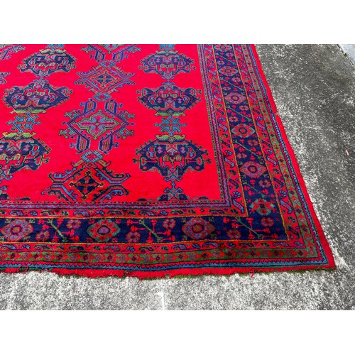 388 - Large Turkoman red ground carpet, hand knotted wool, central field of Ejder designs guls in alternat... 