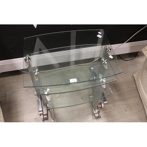 355 - Set of three glass and chrome nest of tables with steel roller feet, approx 49cm H x 60cm W x 46cm D... 
