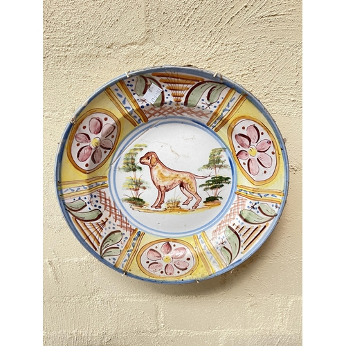 360 - Three antique Portuguese tin glazed pottery wall plates, decorated with Hound, buildings, blue bird ... 