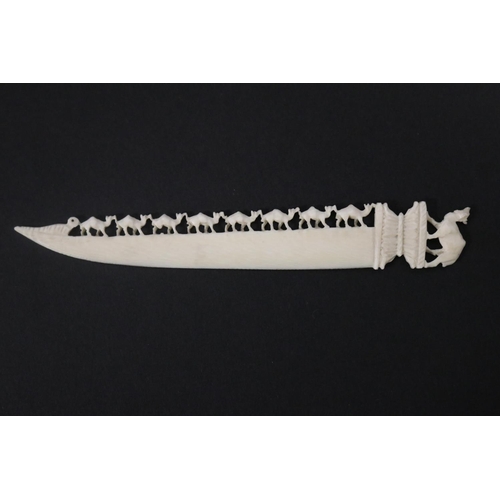 115 - Carved ivory letter opener, carved with chains of camels, approx 16cm L