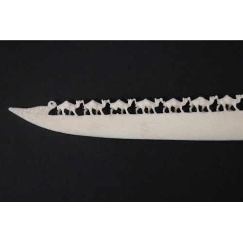 115 - Carved ivory letter opener, carved with chains of camels, approx 16cm L