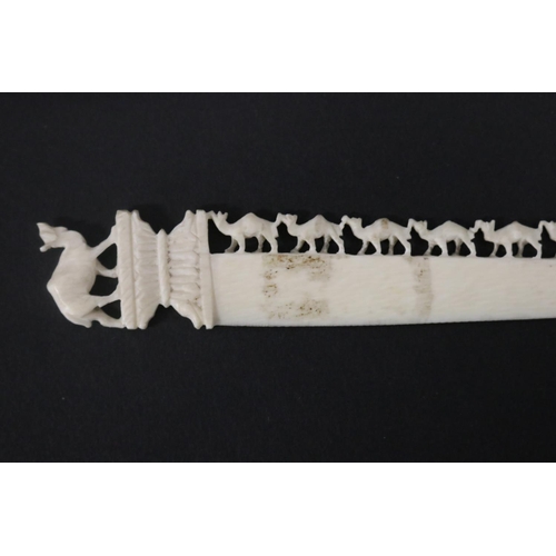 115 - Carved ivory letter opener, carved with chains of camels, approx 16cm L