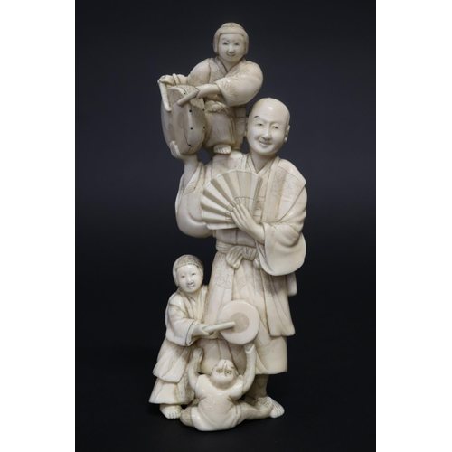 122 - Well carved Japanese okimono ivory figure group of man with fan, with little children beating drums,... 