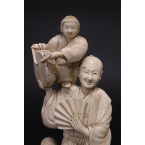 122 - Well carved Japanese okimono ivory figure group of man with fan, with little children beating drums,... 