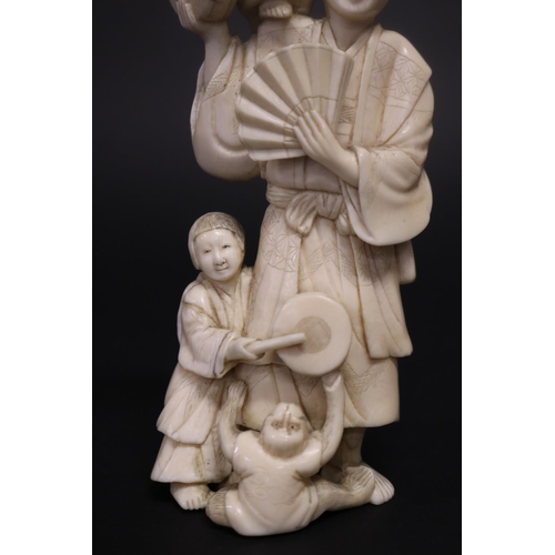 122 - Well carved Japanese okimono ivory figure group of man with fan, with little children beating drums,... 