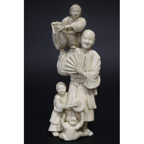 122 - Well carved Japanese okimono ivory figure group of man with fan, with little children beating drums,... 