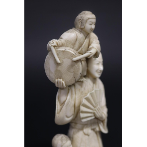 122 - Well carved Japanese okimono ivory figure group of man with fan, with little children beating drums,... 