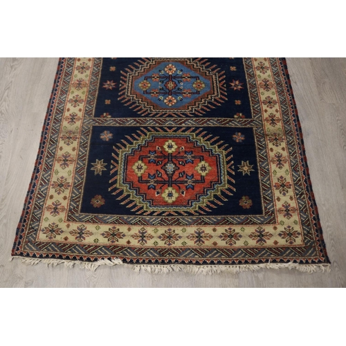 292 - Caucasian hand knotted wool carpet, three central guls on a blue ground, approx 201cm x 140cm