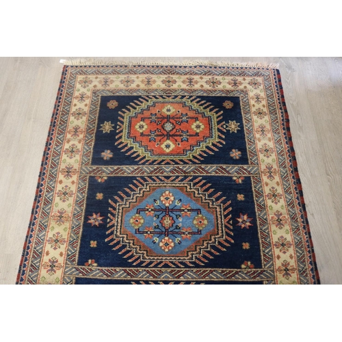 292 - Caucasian hand knotted wool carpet, three central guls on a blue ground, approx 201cm x 140cm