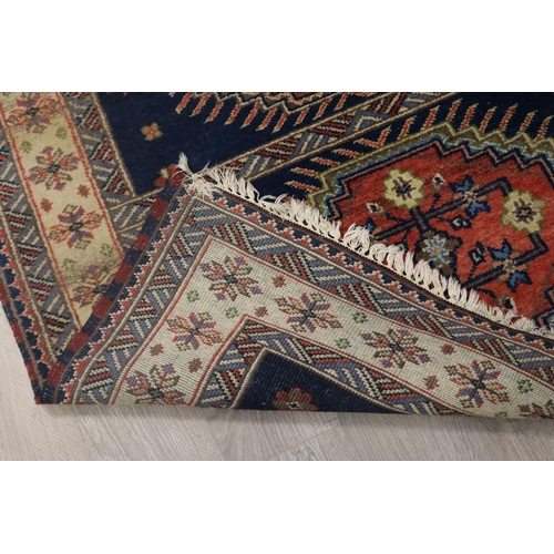 292 - Caucasian hand knotted wool carpet, three central guls on a blue ground, approx 201cm x 140cm