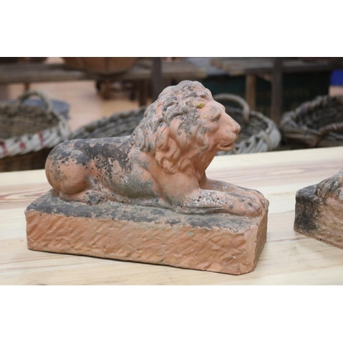 492 - Pair of terracotta garden lions, both seated on plinth, each approx 25cm H x 34cm L (2)
