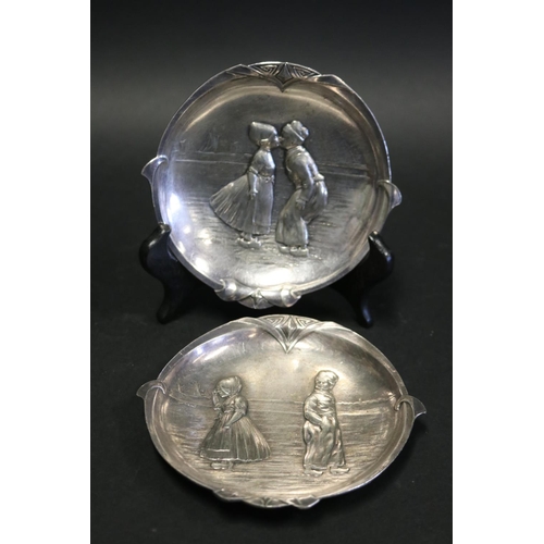 89 - Pair of antique WMF metal dishes, cast in relief with Dutch boys and girls, approx 12.5 cm dia (2)