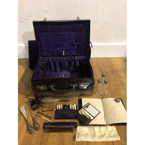 142 - Vintage travelling vanity case and contents, including silver top bottles, brushes etc.