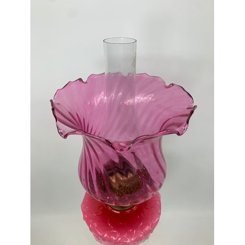 16 - Large Victorian style ruby oil lamp with Corinthian style pillar, 83cm