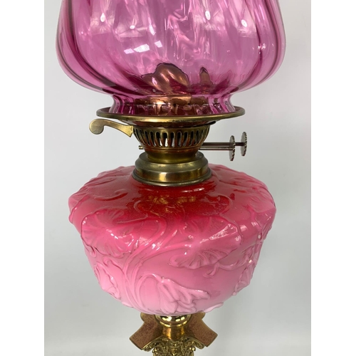 16 - Large Victorian style ruby oil lamp with Corinthian style pillar, 83cm