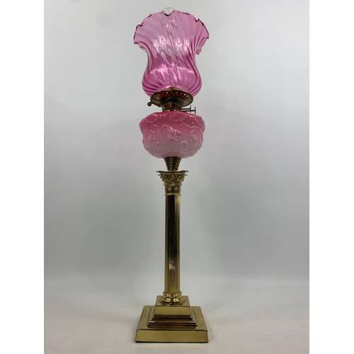 16 - Large Victorian style ruby oil lamp with Corinthian style pillar, 83cm