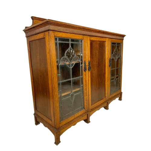 839 - Edwardian Arts & Crafts oak bookcase, with lead glass doors. 134/45/115cm