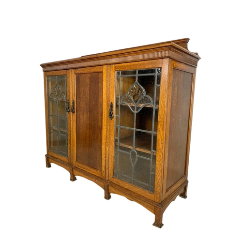 839 - Edwardian Arts & Crafts oak bookcase, with lead glass doors. 134/45/115cm