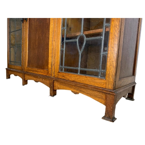 839 - Edwardian Arts & Crafts oak bookcase, with lead glass doors. 134/45/115cm