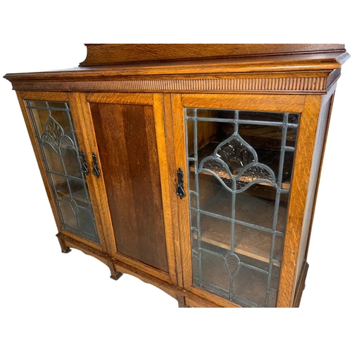 839 - Edwardian Arts & Crafts oak bookcase, with lead glass doors. 134/45/115cm