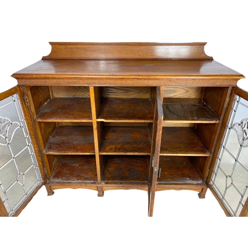 839 - Edwardian Arts & Crafts oak bookcase, with lead glass doors. 134/45/115cm