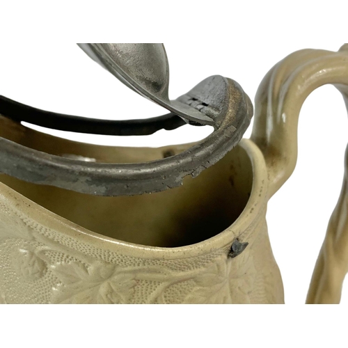 16 - 19th century pottery jug with pewter top. 24cm