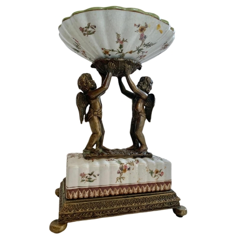 434 - Wong Lee 1895 ornate brass and porcelain pedestal bowl/comport. With cherub figures. 23x17x33.5cm