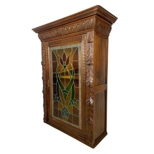 946 - Victorian carved oak wall hanging cabinet with stain glass door. 93/36/119.5cm