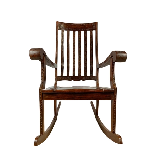 1062 - Carved Indian rosewood rocking chair with brass inlay