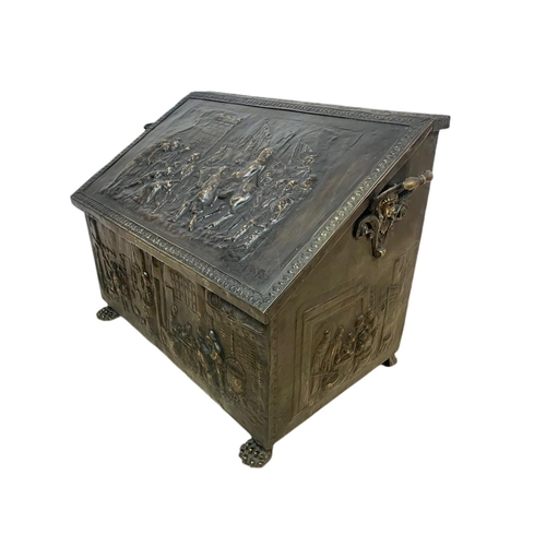 194 - Large Victorian ornate brass log box with lion paw feet and medieval decoration. 71 x 38 x 48cm