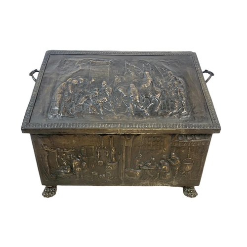 54 - Large Victorian ornate brass log box with lion paw feet and medieval decoration. 71 x 38 x 48cm