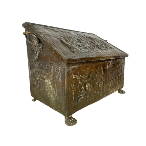 54 - Large Victorian ornate brass log box with lion paw feet and medieval decoration. 71 x 38 x 48cm