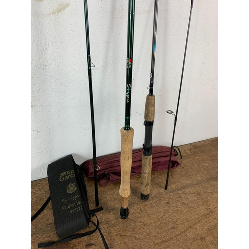 115 - 2 fishing rods. 1 sea rod by Abu Garcia Stigma in bag and fly rod by Shimano in bag.