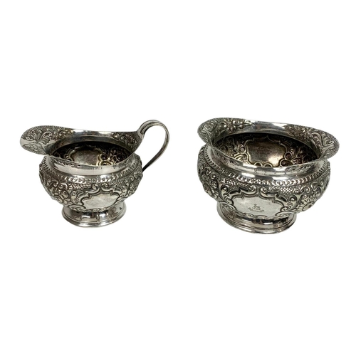 490 - Early 20th century silver plated wine bottle holder, sugar bowl and milk jug, 19cm