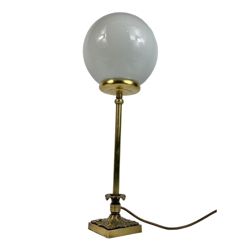 89 - Heavy ornate brass lamp with globe shade, 55cm